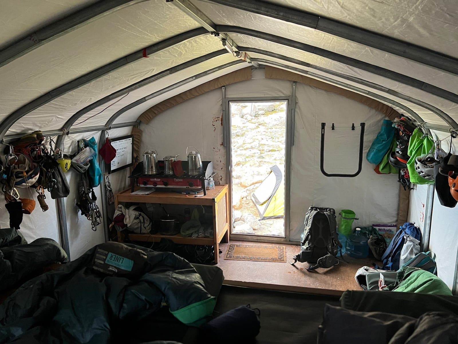 Inside the hut: bunk beds and climbing gear by the door
